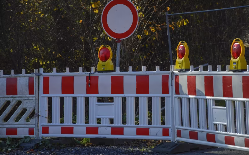 Absperrschranken mit Warnleuchten zur Verkehrssicherung an einer Baustelle